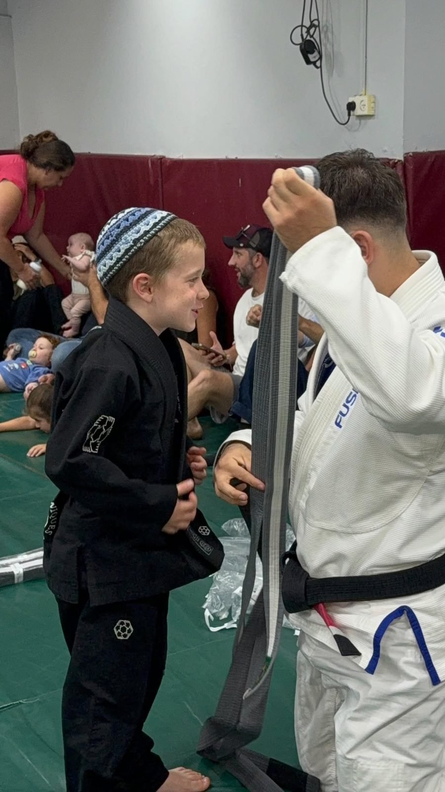 שלו אלנברג מציג חגורה חדשה למתאמן צעיר ב-Fusion BJJ חיפה
