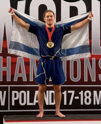 קוסטה מיננקו, מאמן ב-Fusion BJJ חיפה, על הפודיום עם מדליה ודגל ישראל בתחרות ג'יו ג'יטסו בפולין